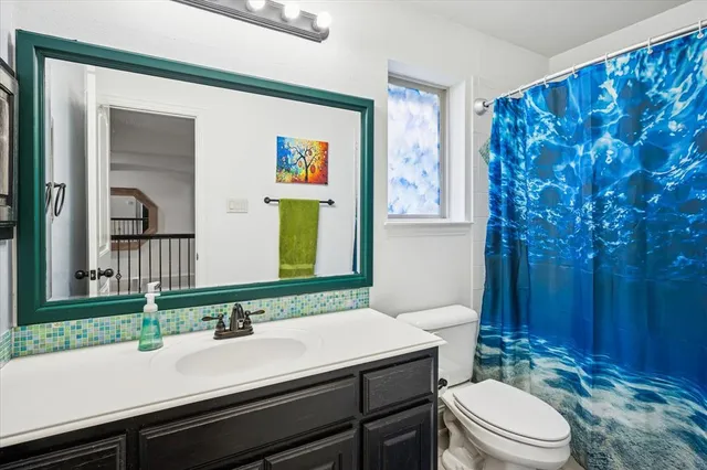 a bathroom with a sink a toilet and mirror