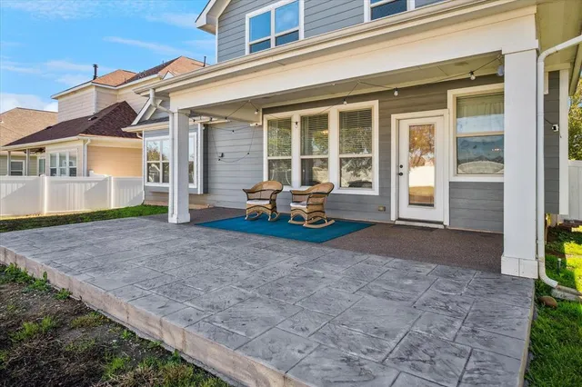 a front view of a house with a large window and potted plants