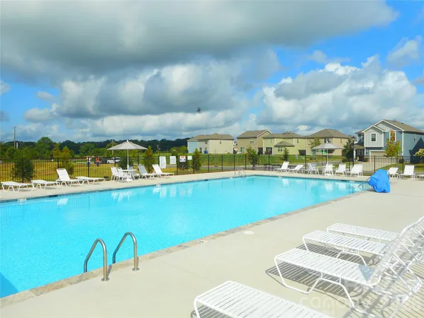a view of a house with a yard and potted plants