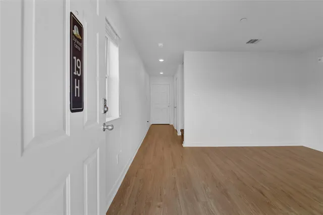 a view of a room with wooden floor and a bathroom