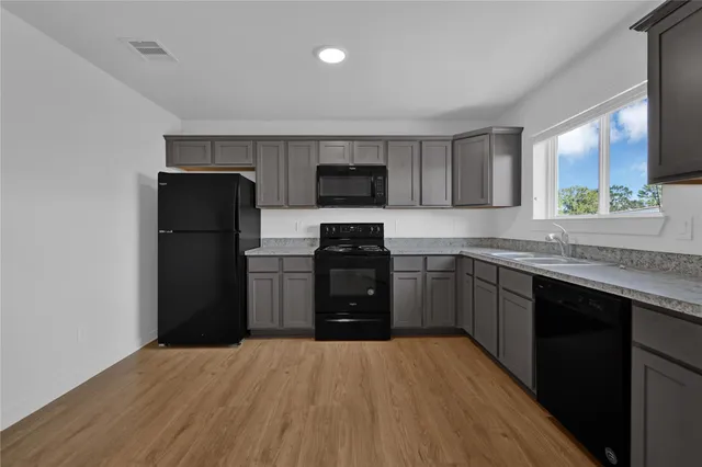 a kitchen with a refrigerator and a stove top oven