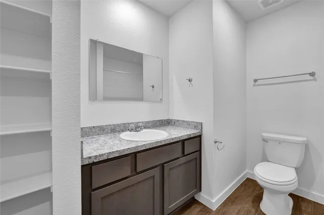 a bathroom with a granite countertop toilet and a sink