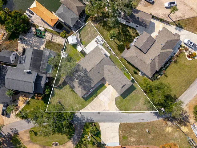 an aerial view of ocean and residential houses with outdoor space