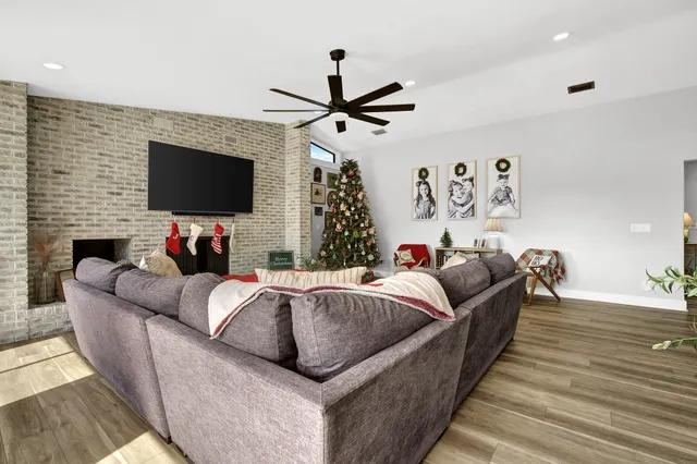 a living room with furniture a chandelier and a wooden floor