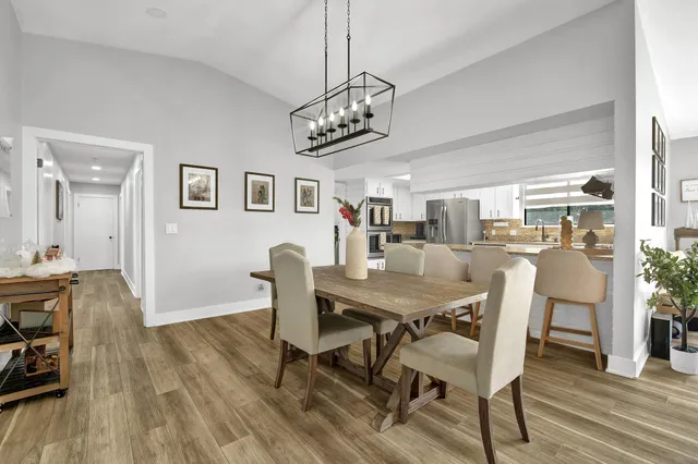 a kitchen with stainless steel appliances white cabinets and wooden floor