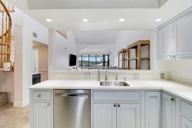 a kitchen with white cabinets stainless steel appliances and sink