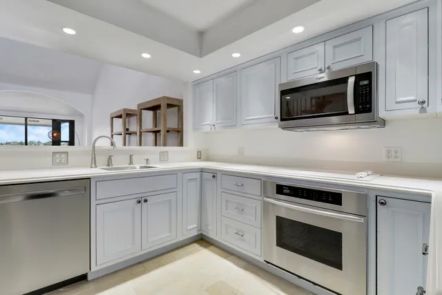 a kitchen with a window a sink and cabinets