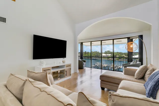 a living room with furniture large windows and a floor to ceiling window