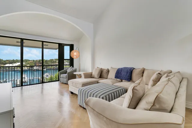 a living room with furniture a flat screen tv and a floor to ceiling window