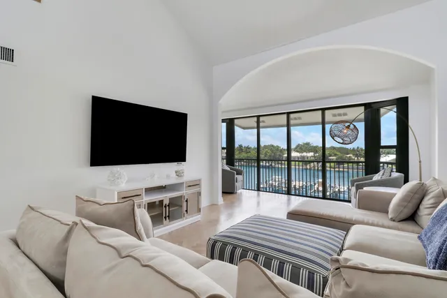 a living room with a couch a flat screen tv and a floor to ceiling window