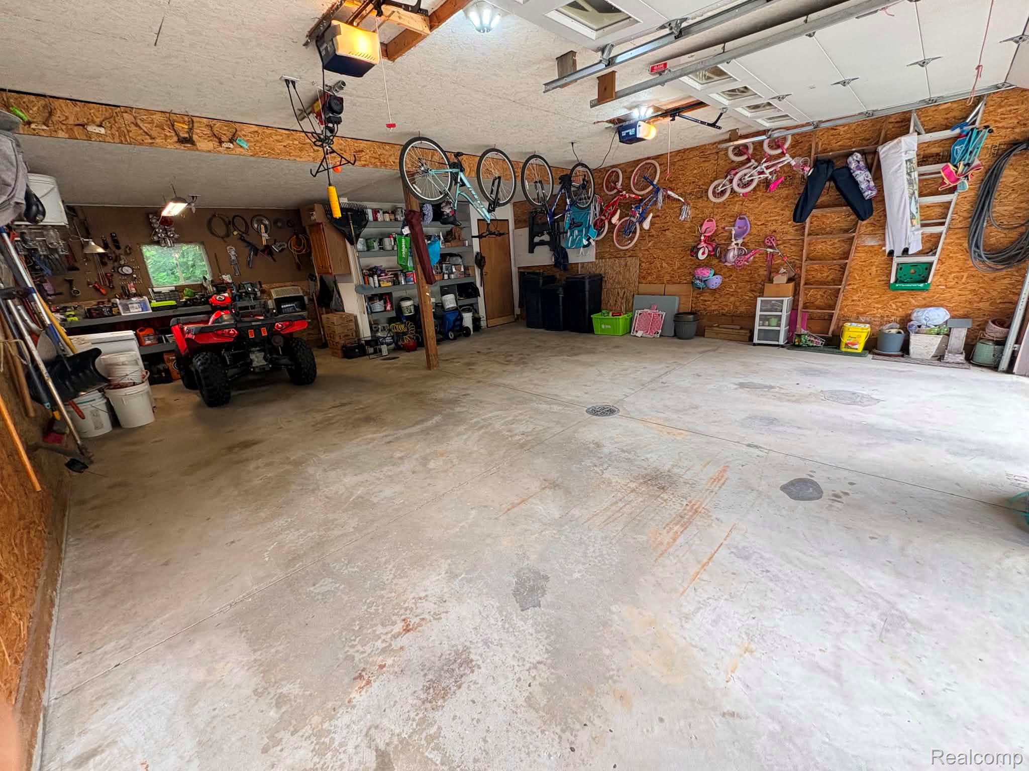 2159 East Bevens Road Caro, MI 48723 - Photo 29 of 38 Spacious garage featuring concrete flooring, exposed wood-finish walls, and ceiling-mounted garage door openers