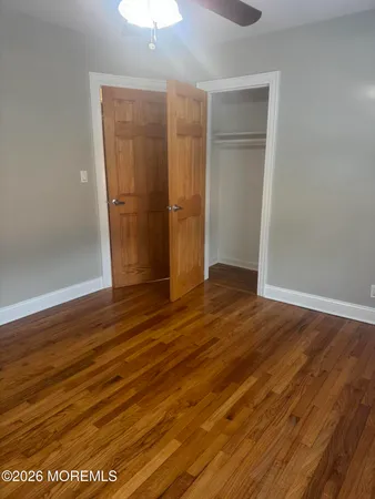 an empty room with wooden floor and closet
