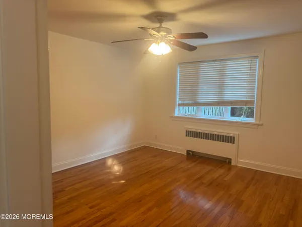 a view of a room with wooden floor and fan