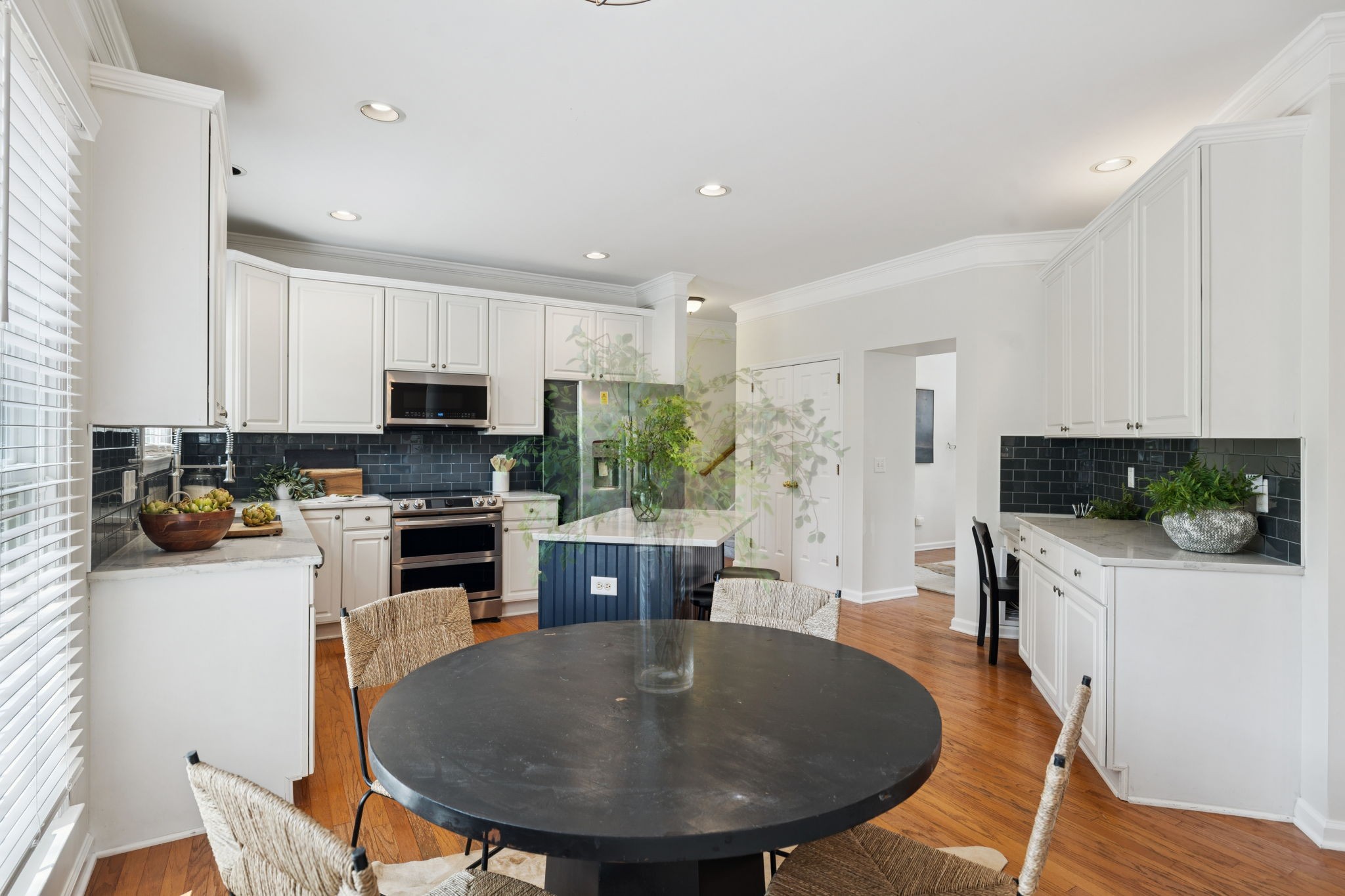 333 Springhouse Circle Franklin, TN 37067 - Photo 25 of 67 a kitchen with stainless steel appliances granite countertop a stove a sink a refrigerator a microwave oven with a dining table and chairs
