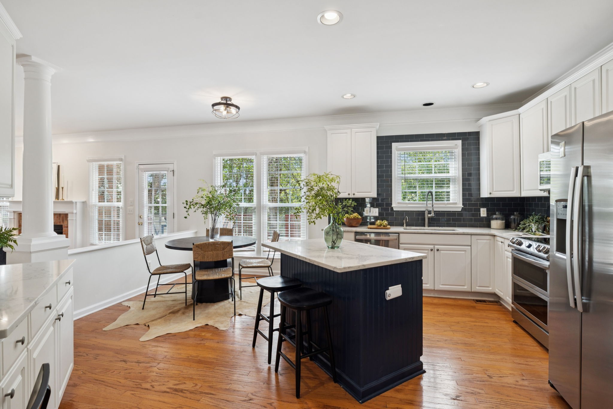 333 Springhouse Circle Franklin, TN 37067 - Photo 29 of 67 a kitchen with stainless steel appliances granite countertop a stove top oven a sink dishwasher a dining table and chairs with wooden floor
