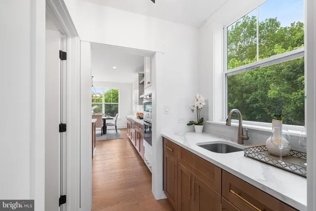 a hallway with white cabinets and wooden floor