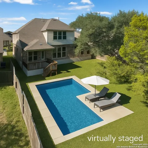 a view of a house with pool and chairs