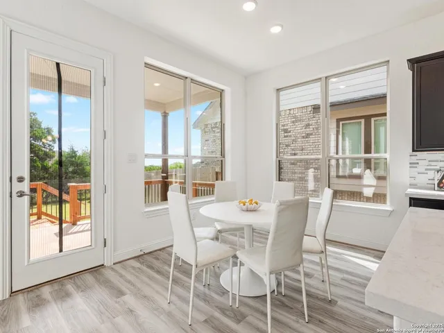 a dining room with furniture a chandelier and window