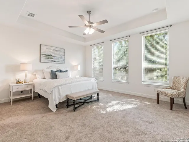 a bedroom with a bed a window and a flat screen tv
