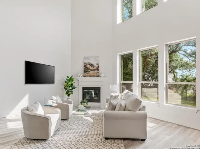 a living room with furniture a flat screen tv and a fireplace