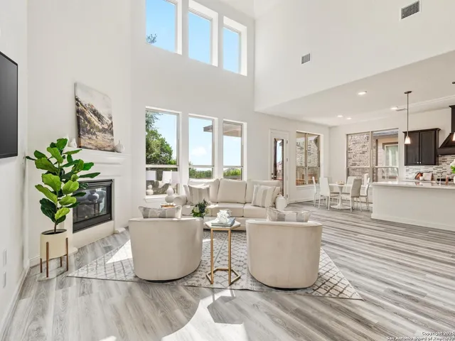 a large kitchen with stainless steel appliances kitchen island granite countertop a refrigerator a oven a sink and a dining table with wooden floor