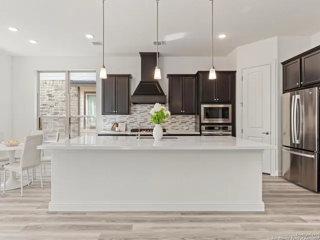 a large kitchen with kitchen island a large island in it