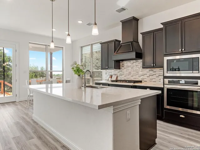 a kitchen with kitchen island granite countertop a sink and cabinets