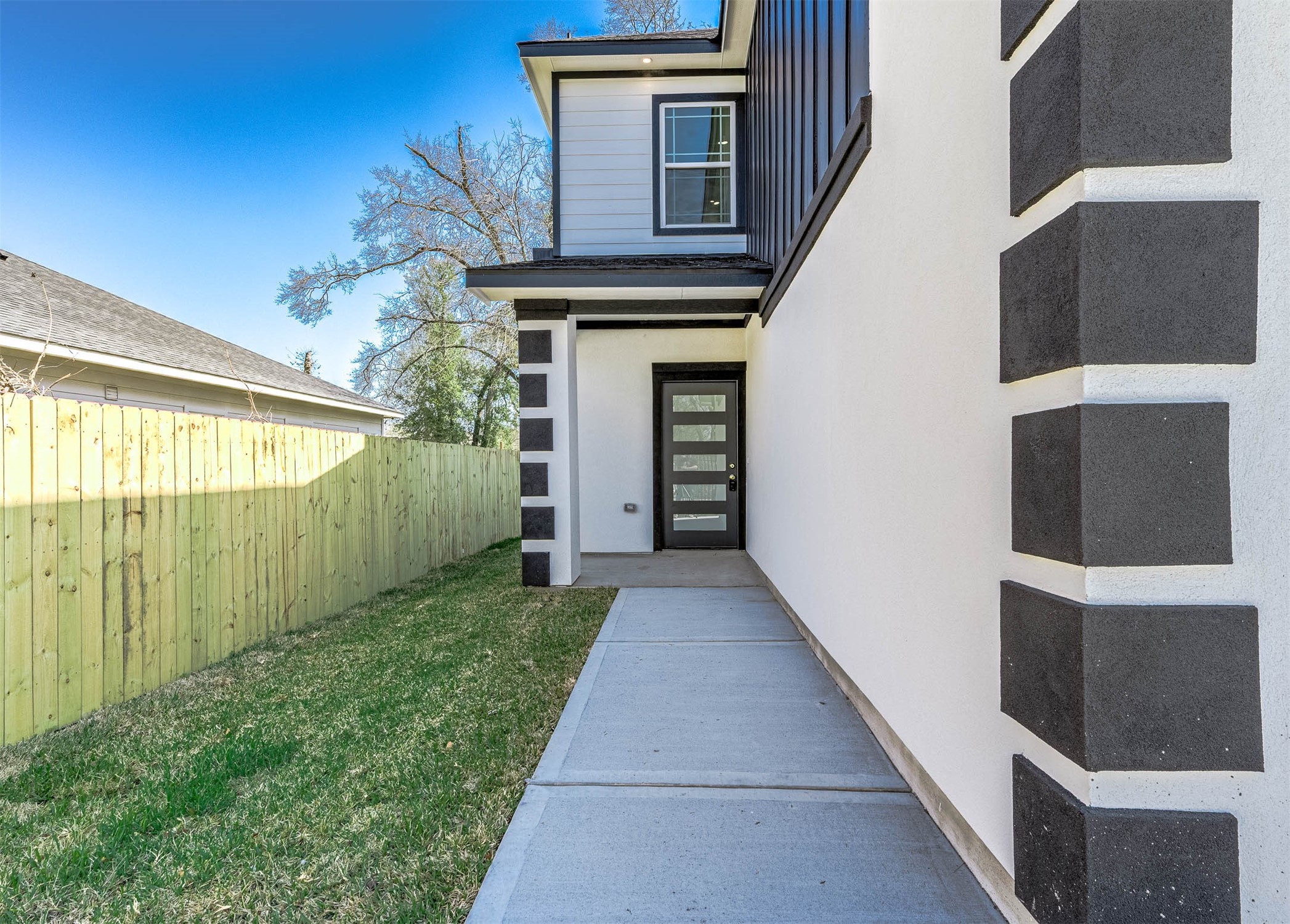 8602 Hoffman Street Houston, TX 77016 - Photo 5 of 30 Walkway to the front entrance featuring a covered entry and clean, modern exterior details.