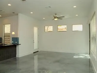 an empty room with a mirror and a ceiling fan