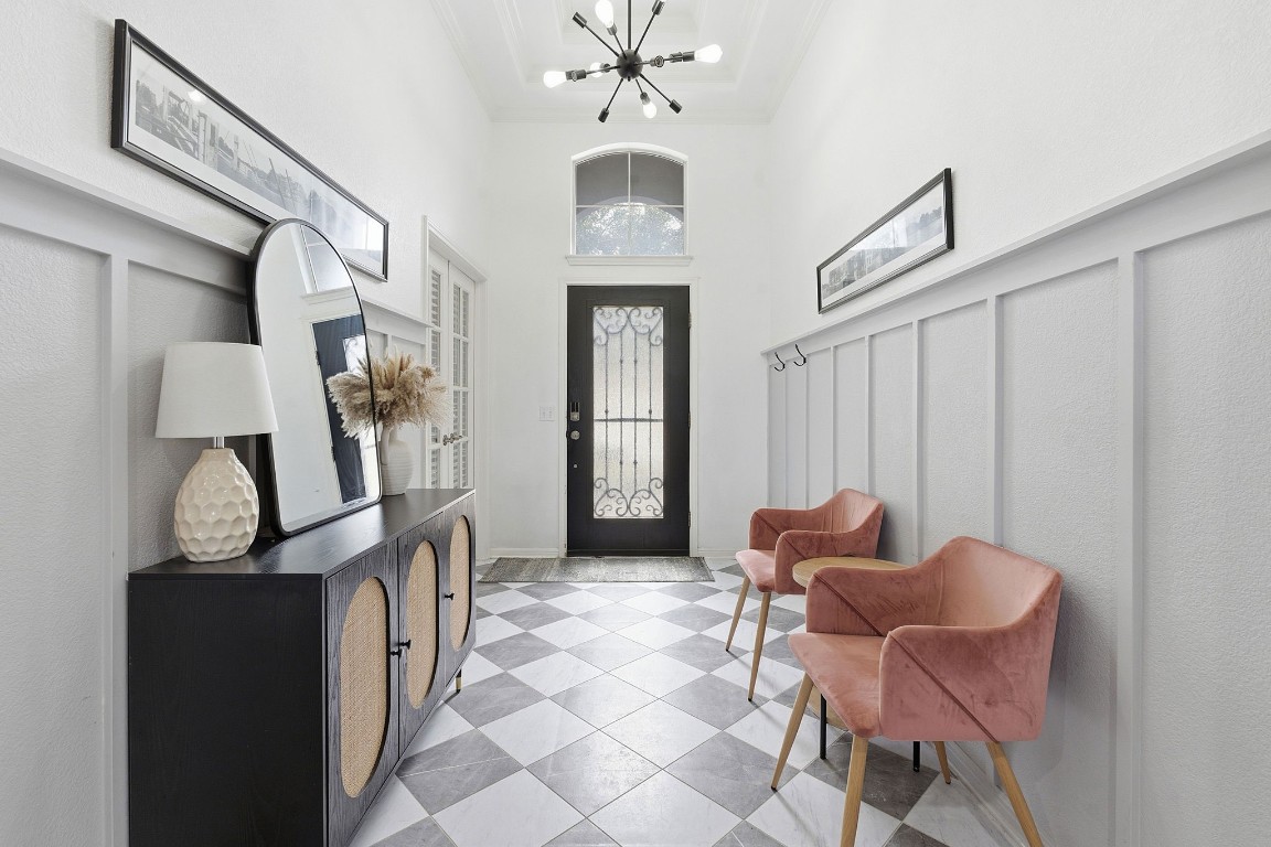 150 Manchester Lane Austin, TX 78737 - Photo 2 of 24 Foyer with a towering ceiling and a chandelier