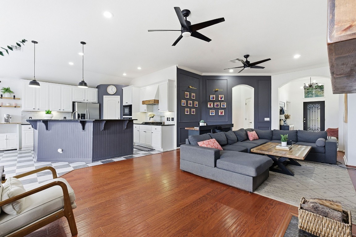 150 Manchester Lane Austin, TX 78737 - Photo 6 of 24 Living area featuring ceiling fan, light wood-style flooring, arched walkways, and recessed lighting