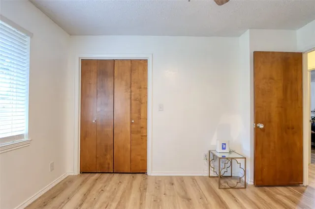 an empty room with wooden floor and closet area