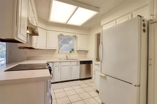 a kitchen with a sink a refrigerator and cabinets
