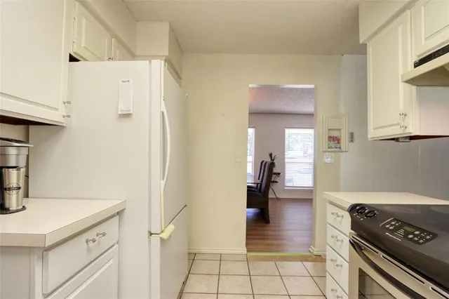 a kitchen with a refrigerator and a stove top oven