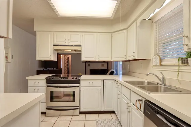 a kitchen with a stove sink and cabinets