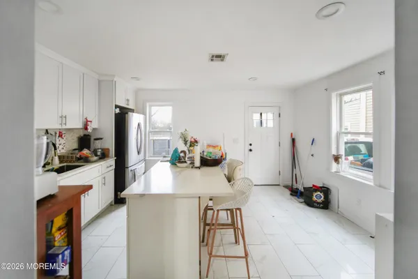 a kitchen with white cabinets and stainless steel appliances