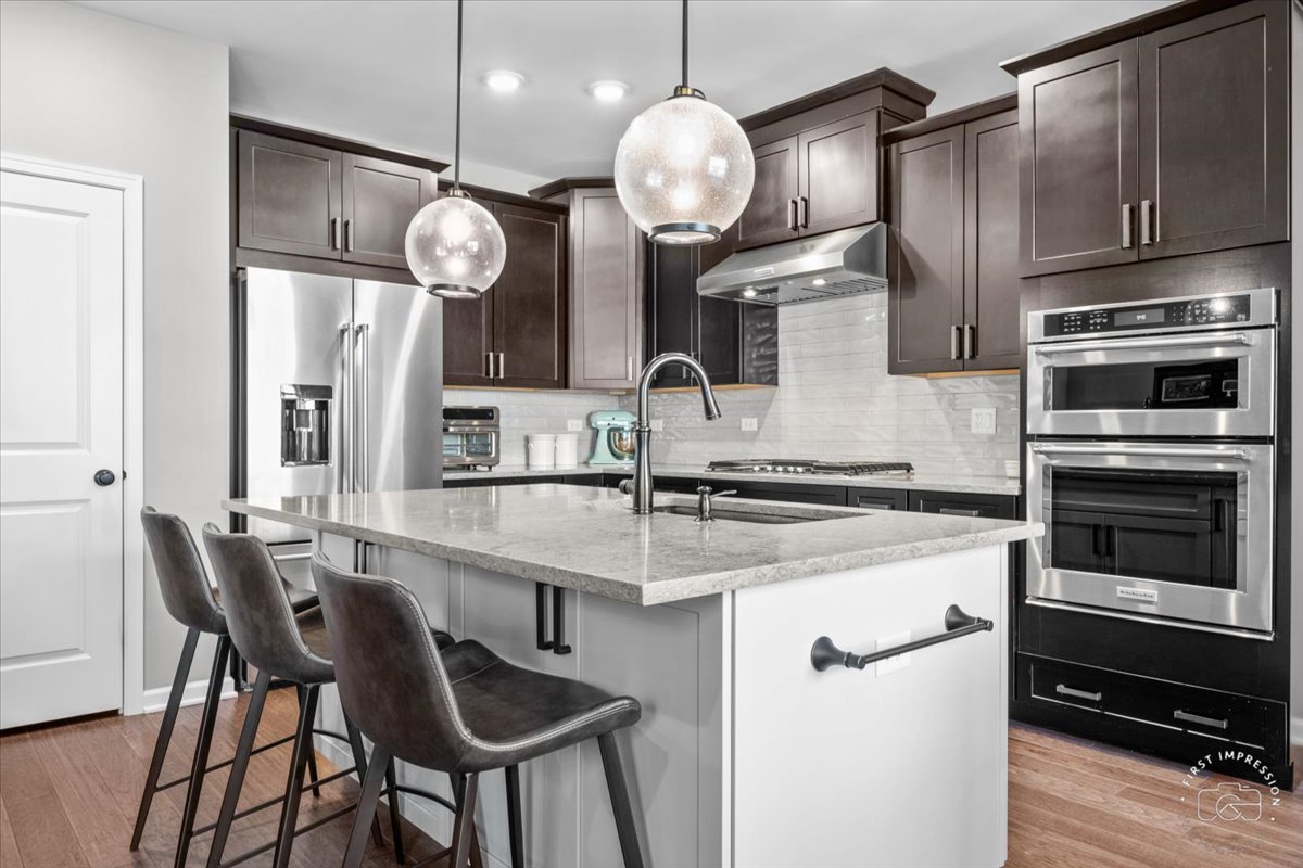 1261 Falcon Ridge Drive Elgin, IL 60124 - Photo 9 of 25 a kitchen with stainless steel appliances a stove a sink island and a refrigerator