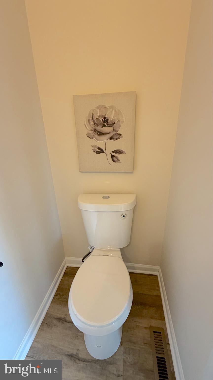 63 Raphael Road Smyrna, DE 19977 - Photo 9 of 27 a bathroom with a toilet and a picture on the wall