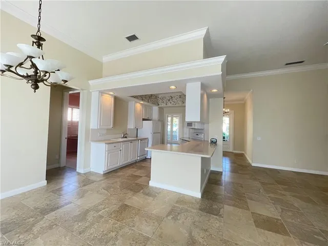a view of a living room and kitchen with stainless steel appliances
