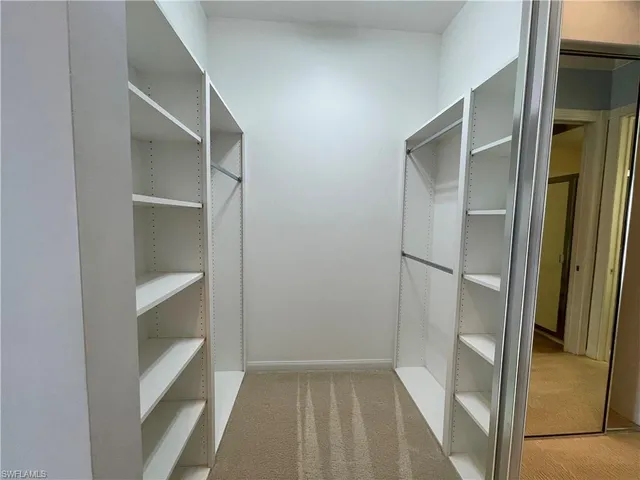 a view of walk in closet with empty racks