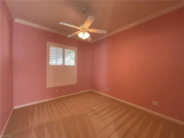 a view of an empty room with a chandelier fan