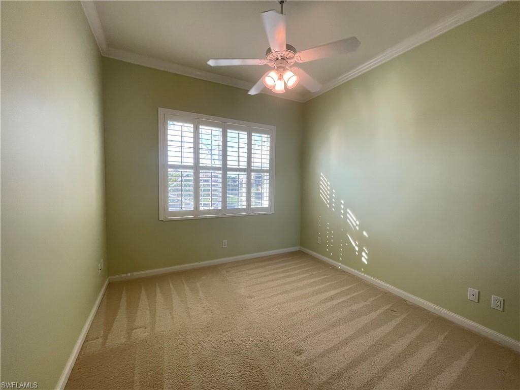 7025 Leopardi Court Naples, FL 34114 - Photo 27 of 48 an empty room with a chandelier fan and windows