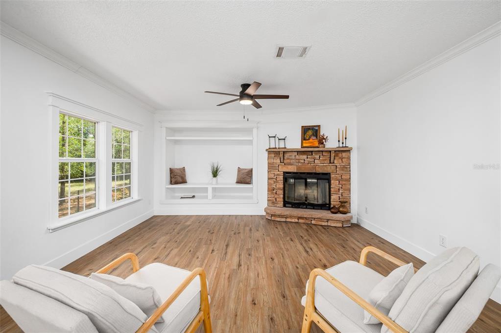 13076 Southwest 154th Street Archer, FL 32618 - Photo 20 of 60 a living room with a fireplace furniture a ceiling fan and a window