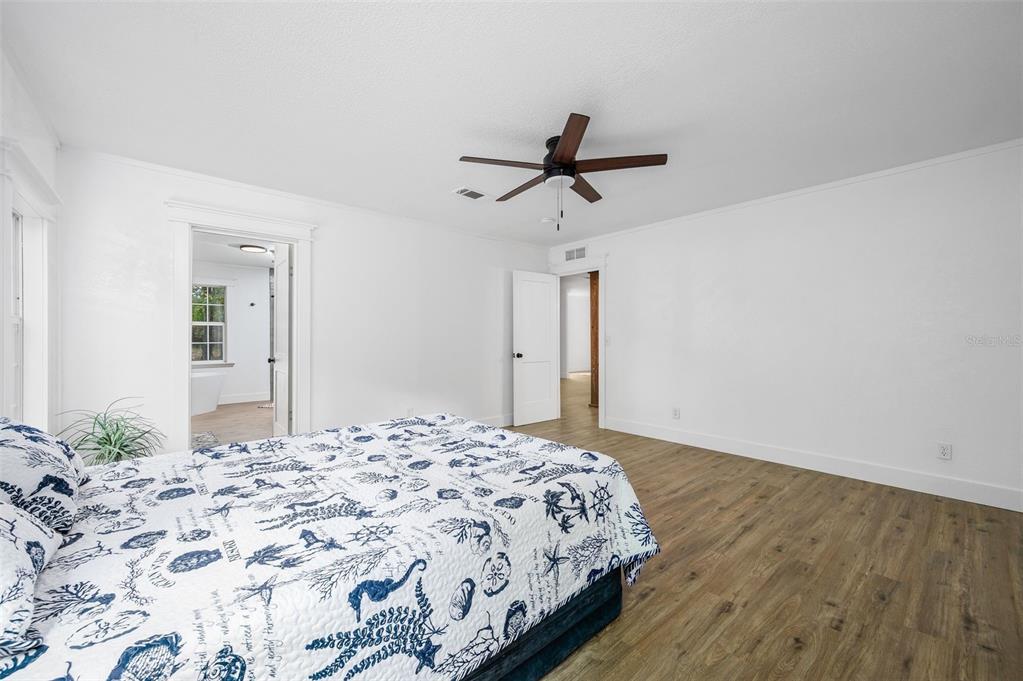 13076 Southwest 154th Street Archer, FL 32618 - Photo 27 of 60 a bedroom with a large bed and a chandelier