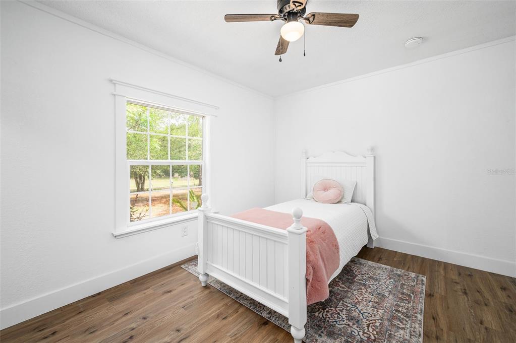 13076 Southwest 154th Street Archer, FL 32618 - Photo 34 of 60 a bedroom with a bed and wooden floor