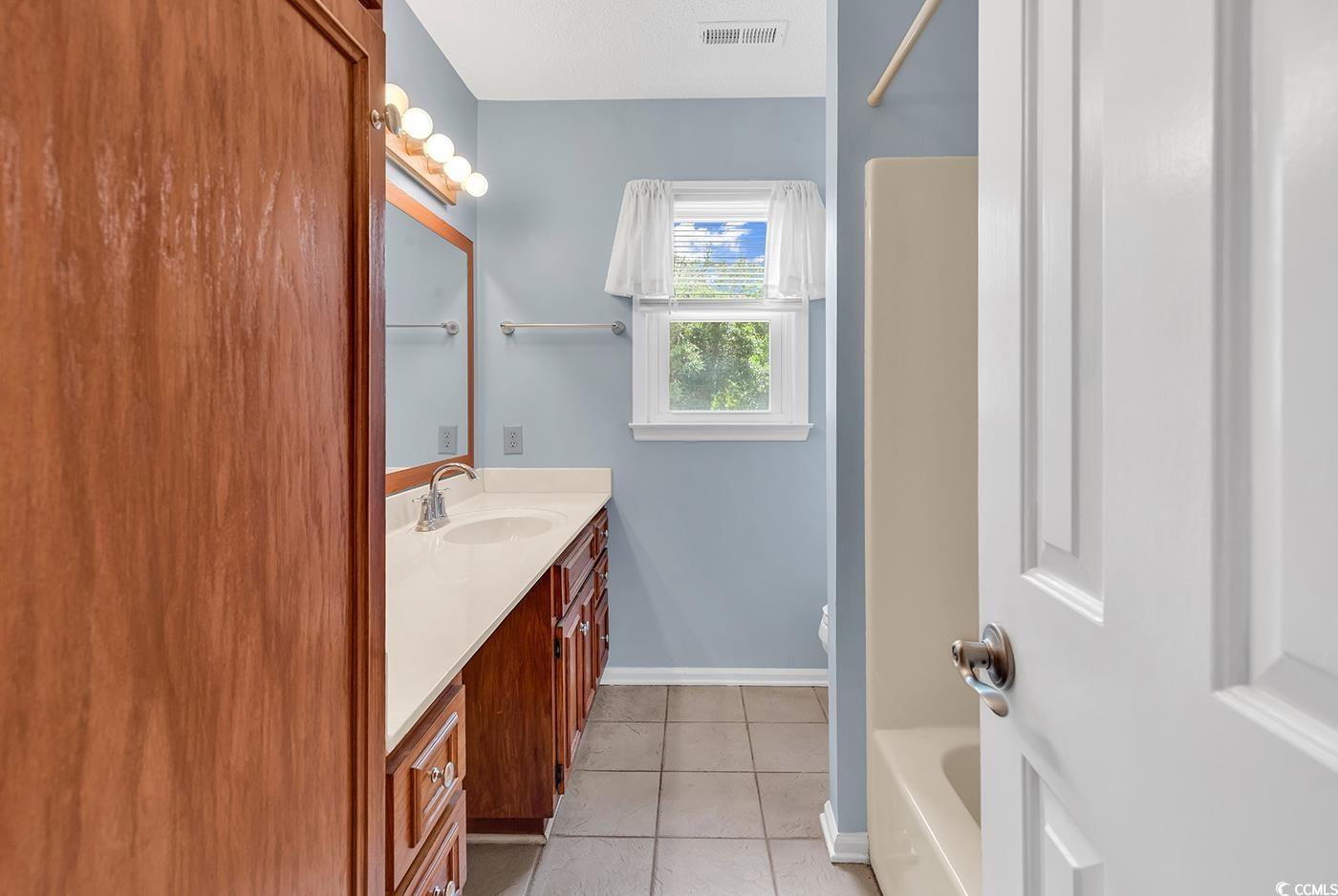 317 14th Avenue North Surfside Beach, SC 29575 - Photo 21 of 40 Bathroom with vanity, tile patterned flooring, and