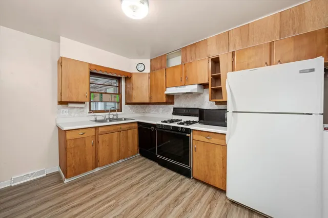 a kitchen with stainless steel appliances granite countertop a refrigerator stove top oven and sink