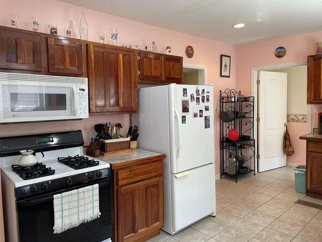 a kitchen with a refrigerator and a stove top oven