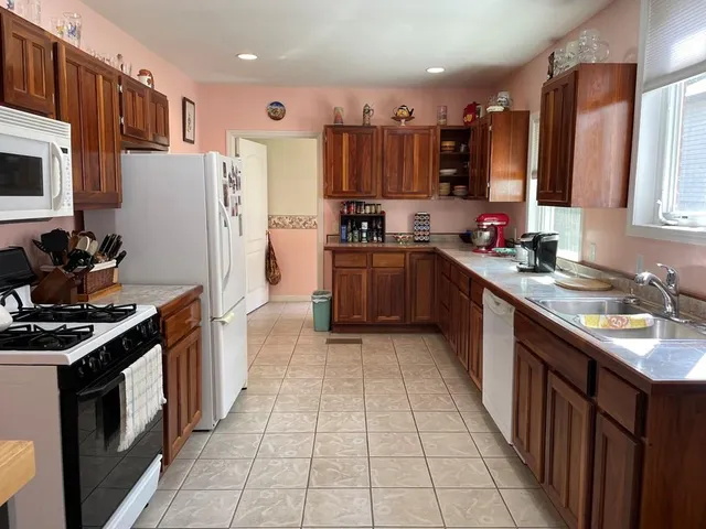 a kitchen with stainless steel appliances granite countertop a stove a sink dishwasher and a refrigerator