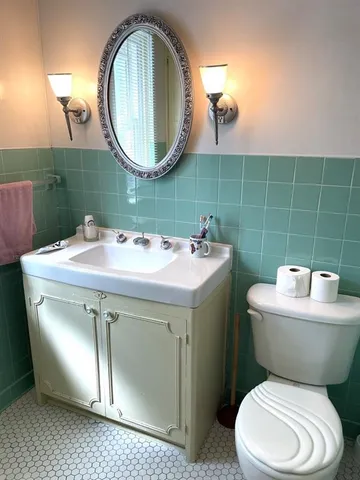 a bathroom with a toilet sink and mirror